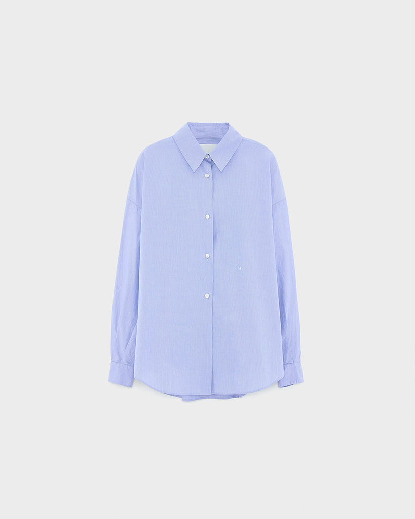 Niebieska, oversizowa koszula w cienkie prążki Gillian Bellerose z opadającymi ramionami i szerokimi rękawami zakończonymi wąskimi mankietami. Zapinana na guziki. Posiada bardzo ciekawą opcję asymetrycznego zapięcia i zwężenia w talii.