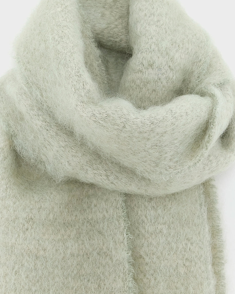 Ciepły, duży, zielony szalik Myllem Bellerose z kontrastowymi frędzlami. Posiada dużą naszywkę z logo marki. Wykonany z miękkiej dzianiny z wełną i moherem.