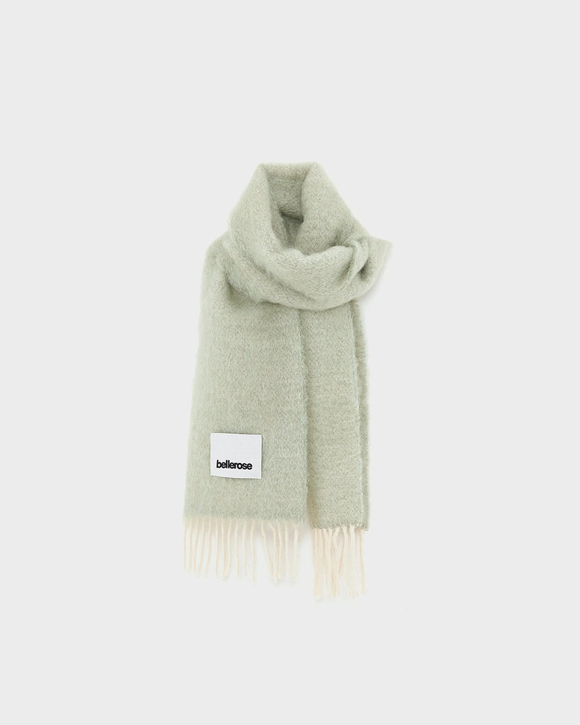 Ciepły, duży, zielony szalik Myllem Bellerose z kontrastowymi frędzlami. Posiada dużą naszywkę z logo marki. Wykonany z miękkiej dzianiny z wełną i moherem.
