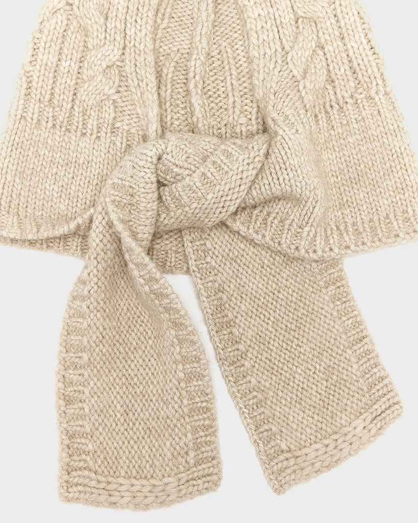 Dzianinowy, ciepły kapturek w stylu balaclavy Nan Bellerose z plecionym, warkoczowym wzorem. Wiązana pod szyją za pomocą szalika. Wykonana z dzianiny z wełną i alpaką.