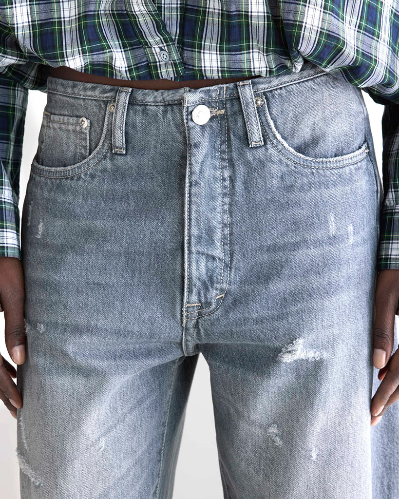 Luźne, szare jeansy z niskim stanem Pacy Bellerose z zaokrągloną nogawką i dwoma szwami po bokach. Wykonane z bawełnianego denimu z przetarciami. Spodnie mają pięć kieszeni. Zapinane na guzik i zamek błyskawiczny.