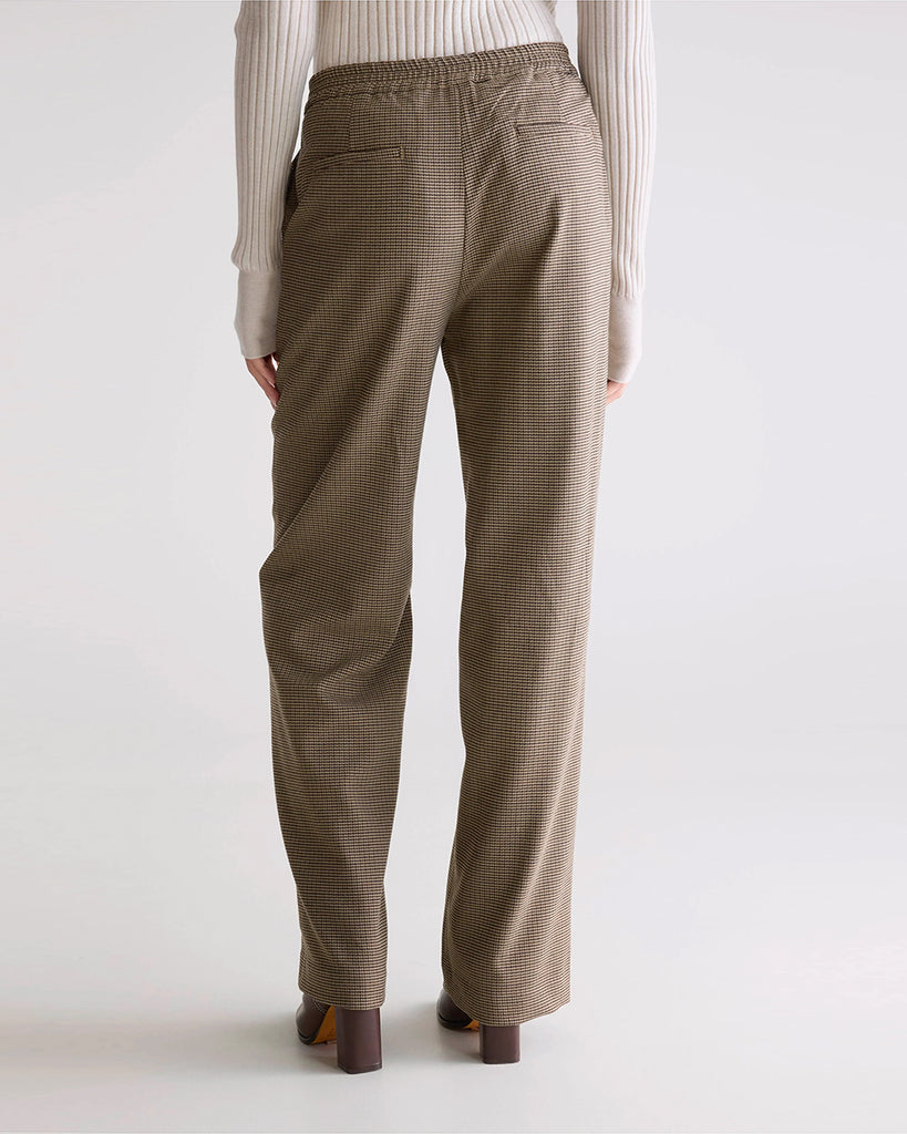 Luźne, materiałowe spodnie w drobną kratkę Tilla Bellerose ze średnim stanem z prostą, długą nogawką. Z tyłu elastyczne w pasie. Z przodu zapinane na guzik umieszczony z boku i zamek błyskawiczny. Spodnie mają dwie, boczne kieszenie i dwie tylne.