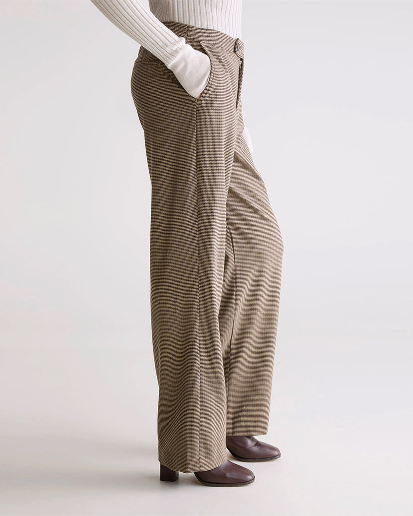 Luźne, materiałowe spodnie w drobną kratkę Tilla Bellerose ze średnim stanem z prostą, długą nogawką. Z tyłu elastyczne w pasie. Z przodu zapinane na guzik umieszczony z boku i zamek błyskawiczny. Spodnie mają dwie, boczne kieszenie i dwie tylne.