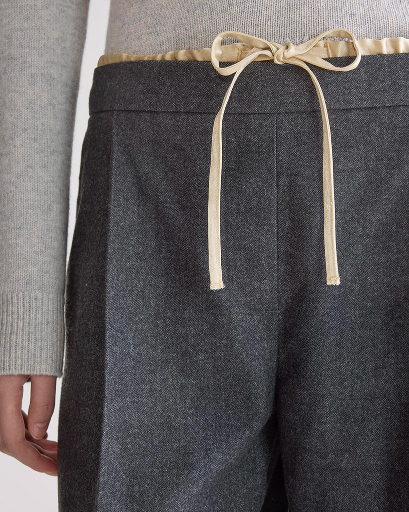 Luźne, materiałowe spodnie Turin Bellerose ze średnim stanem i elastycznym, wiązanym, warstwowym pasem. Spodnie mają szeroką, prostą nogawkę z kantem. Wykonane z miękkiej tkaniny z wiskozą