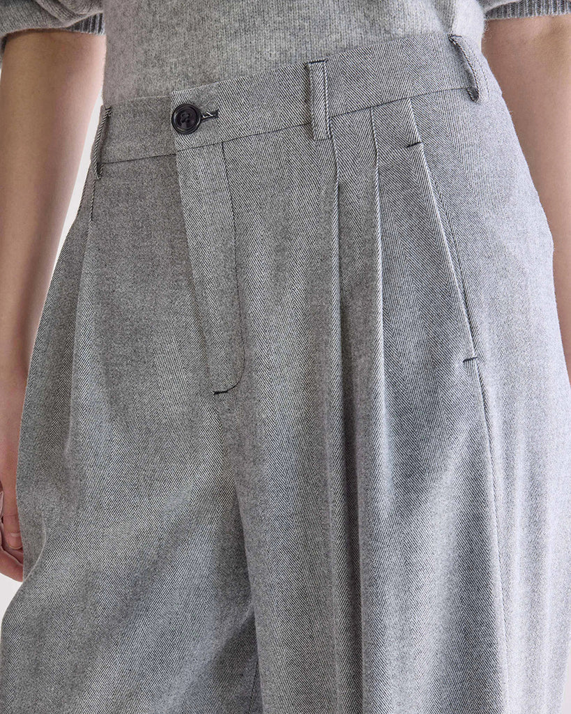 Luźne, materiałowe spodnie Volkert Bellerose z wysokim stanem i zakładkami. Spodnie mają szeroką, prostą nogawkę. Wykonane z miękkiej tkaniny z wiskozą w drobny wzór w jodełkę. Spodnie mają dwie boczne i dwie tylne kieszenie.