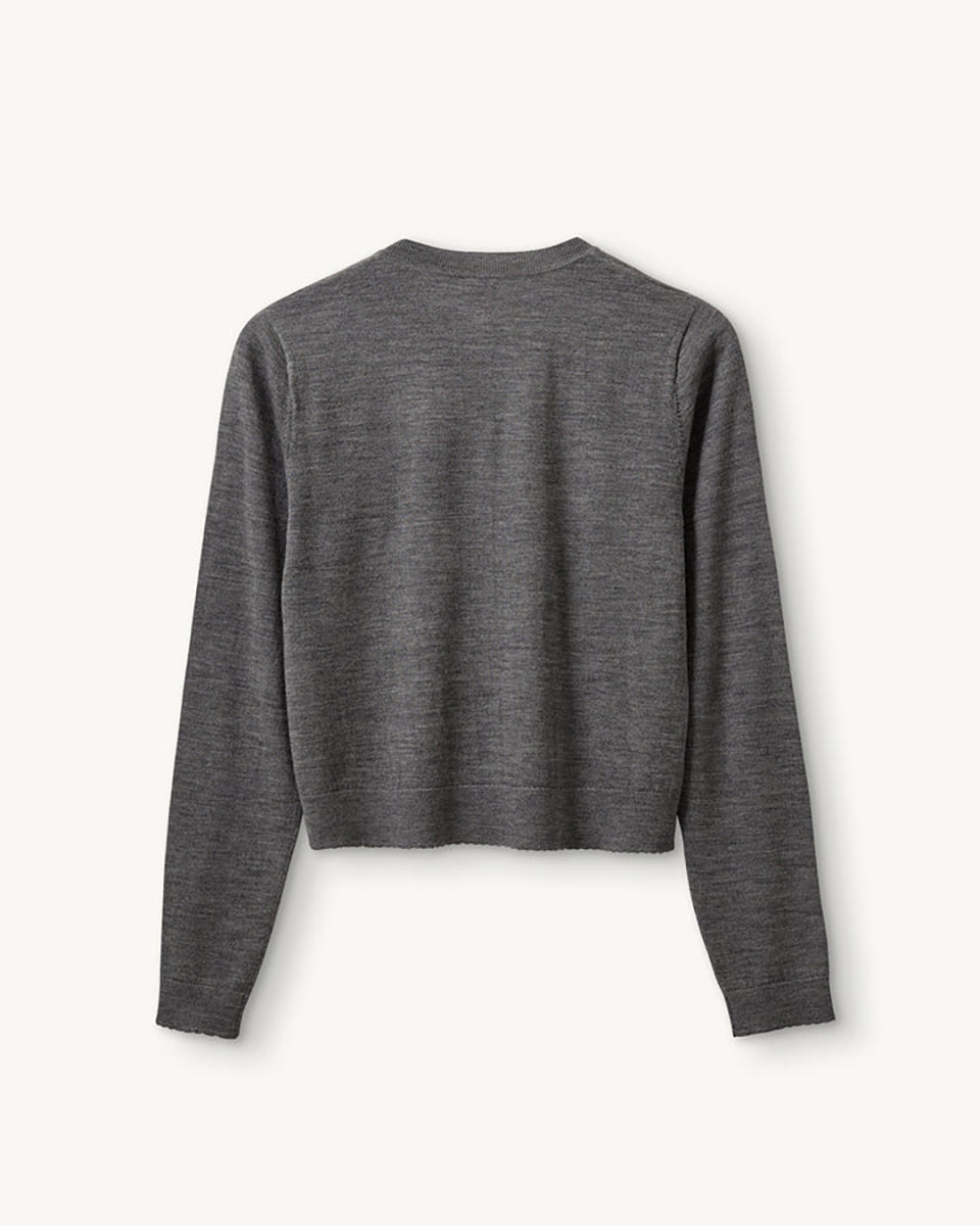 Dzianinowy, swobodny kardigan Bergen Scallop Grey Melange o prostym kroju i długich rękawach. Wyróżnia się subtelnym, ażurowym detalem na przodzie, inspirowanym koronką, który nadaje całości ciekawą fakturę. Jest lekki, a zarazem przytulny- idealnie sprawdza się w warstwowych stylizacjach, tworząc delikatny i wyrafinowany zestaw na co dzień. Wykonany z wełny merino.

-Swobodny, prosty krój

-100% wełna merino