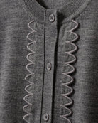 Dzianinowy, swobodny kardigan Bergen Scallop Grey Melange o prostym kroju i długich rękawach. Wyróżnia się subtelnym, ażurowym detalem na przodzie, inspirowanym koronką, który nadaje całości ciekawą fakturę. Jest lekki, a zarazem przytulny- idealnie sprawdza się w warstwowych stylizacjach, tworząc delikatny i wyrafinowany zestaw na co dzień. Wykonany z wełny merino.

-Swobodny, prosty krój

-100% wełna merino