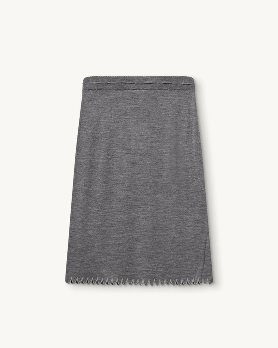 Dzianinowa, prosta spódnica Bergen Scallop Grey Melange z gładkim, elastycznym pasem. Wykonana z materiału o średniej grubości i gładkiej fakturze, który zachowuje swój kształt, a jednocześnie naturalnie się układa. Wiązanie z przodu oraz koronkowe wykończenie dołu nadają jej subtelny, dekoracyjny charakter. Wykonana z wełny merino.

-Dzianinowy model o prostym kroju

-100% wełna merino