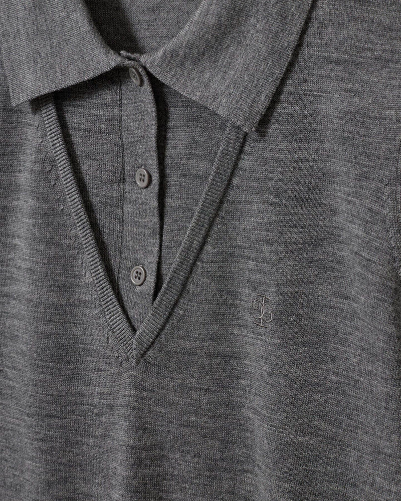 Cienki, wełniany sweter polo Bergen The Garment z kołnierzykiem imitacją dekoltu w serek. Wykonany z miękkiej dzianiny z wełny merynosa. Sweter ma luźny krój i wykończony jest ściągaczami.