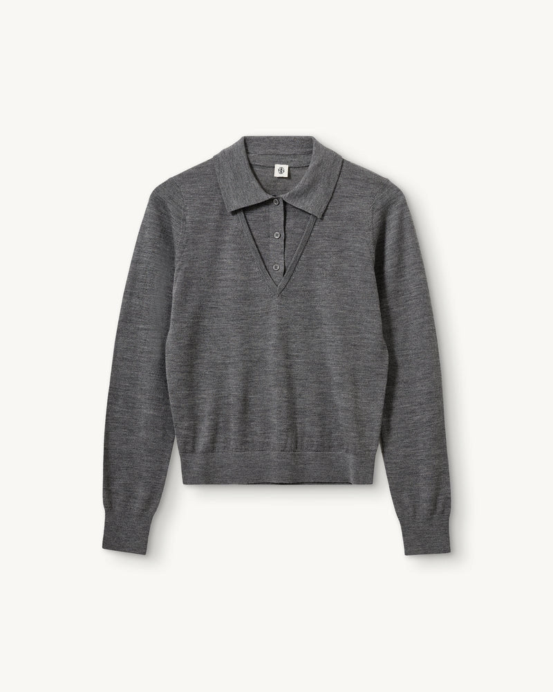 Cienki, wełniany sweter polo Bergen The Garment z kołnierzykiem imitacją dekoltu w serek. Wykonany z miękkiej dzianiny z wełny merynosa. Sweter ma luźny krój i wykończony jest ściągaczami.