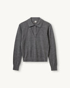 Cienki, wełniany sweter polo Bergen The Garment z kołnierzykiem imitacją dekoltu w serek. Wykonany z miękkiej dzianiny z wełny merynosa. Sweter ma luźny krój i wykończony jest ściągaczami.