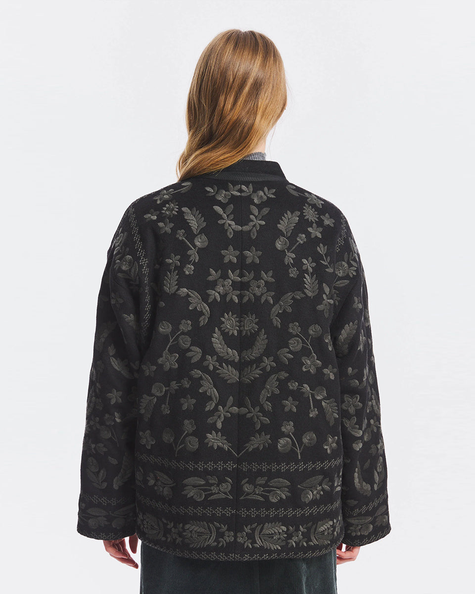 Luźna, lekko pudełkowa kurtka Bertille Antik Batik Black z mieszanki wełny, w całości ozdobiona haftem z kwiatowym motywem. Posiada dwie kieszenie z przodu. Zamek błyskawiczny wyróżniono ozdobnymi plecionkami, które nadają całości charakter boho. Charakterystycznym elementem są ozdobne, tradycyjne chińskie węzełki służące jako zapięcie. Model ten łączy w sobie inspirację tradycyjnymi ubiorami azjatyckimi z nowoczesną, miejską elegancją.
