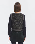 Krótka kamizelka Bertille Black marki Antik Batik o wyraźnym, etnicznym charakterze nawiązującym do stylu boho-chic. Jest to fason sięgający do linii bioder, z otwartym przodem, bez widocznego zapięcia. Przód kamizelki zdobi bogaty, symetryczny haft. Wykonana z mieszanki wełny i bawełny. Wszystkie krawędzie zostały obszyte ozdobną, wzorzystą taśmą z geometrycznym haftem. Zestaw ją z ulubionymi spodniami oraz luźną, białą koszulą z bufiastymi rękawami i wysoką stójką.&nbsp;