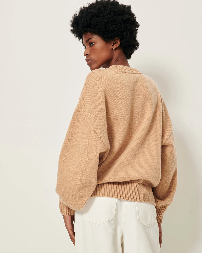 Oversizowy, ciepły sweter Beyeler Milk Tea francuskiej marki Sessun z okrągłym dekoltem i obniżonymi ramionami. Ma szerokie, długie rękawy z dopasowanymi mankietami oraz ściągacz u dołu. Wykonany z dzianiny z mieszanką wełny merino i kaszmiru.
