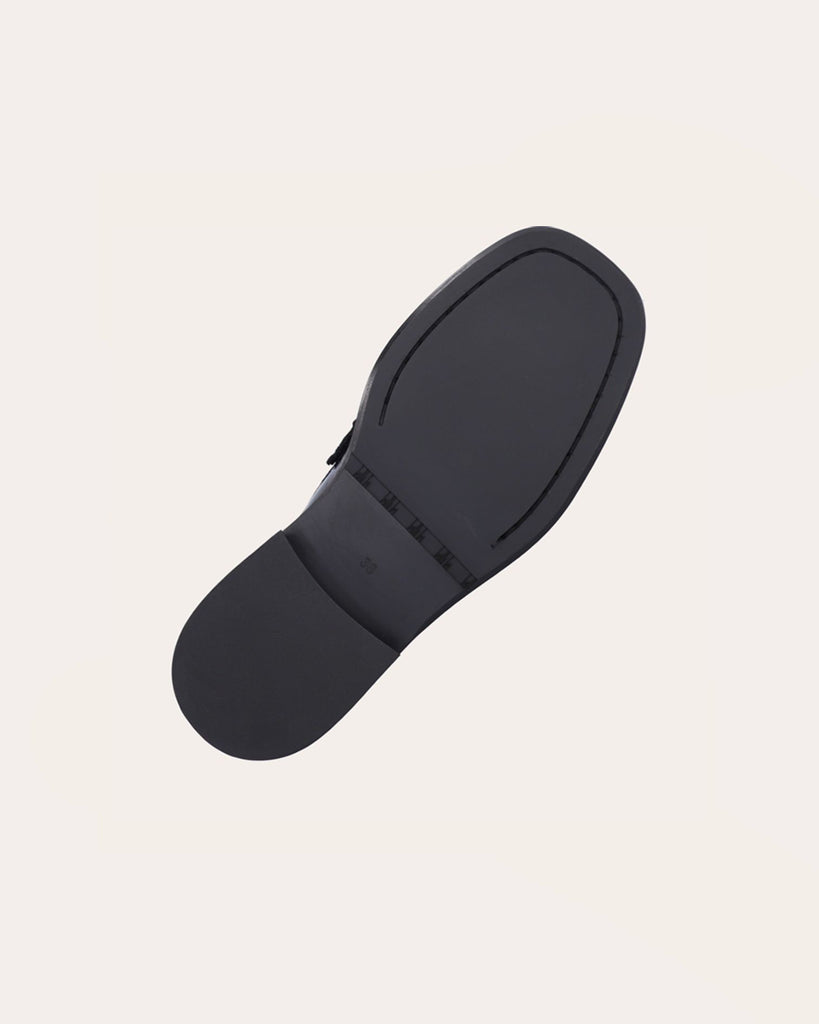 Ręcznie wykonane mokasyny marki Billi Bi Copenhagen z czarnej, lakierowanej skóry z kwadratowym noskiem. Mokasyny zdobi prosty pasek z przodu, a pod spodem dwa frędzle. W przedniej części buta znajduje się wyraźny szew, który tworzy delikatne marszczenie w skórze, podkreślając ręczne wykończenie. Buty mają 3 centymetrowy obcas.