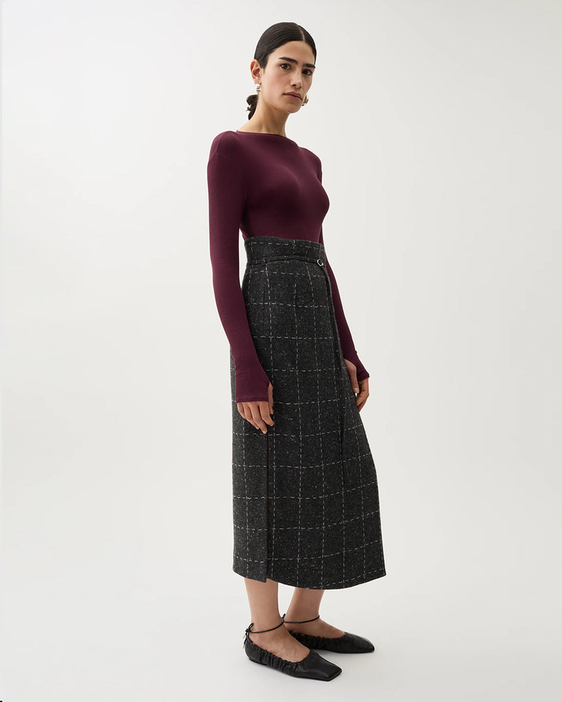 Spódnica midi Blanket Grey Melange w kolorze szarym w kratę. Ma wysoki stan oraz talię w stylu paperbag, którą zdobi sznurek z małą klamrą. Na bokach posiada rozcięcia. Wykonana z mieszanki wełny. Idealnie sprawdzi się do zwiewnych bluzek oraz marynarki Zola Check tej samej marki.&nbsp;
