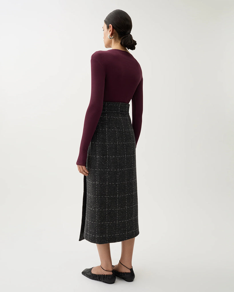 Spódnica midi Blanket Grey Melange w kolorze szarym w kratę. Ma wysoki stan oraz talię w stylu paperbag, którą zdobi sznurek z małą klamrą. Na bokach posiada rozcięcia. Wykonana z mieszanki wełny. Idealnie sprawdzi się do zwiewnych bluzek oraz marynarki Zola Check tej samej marki.&nbsp;
