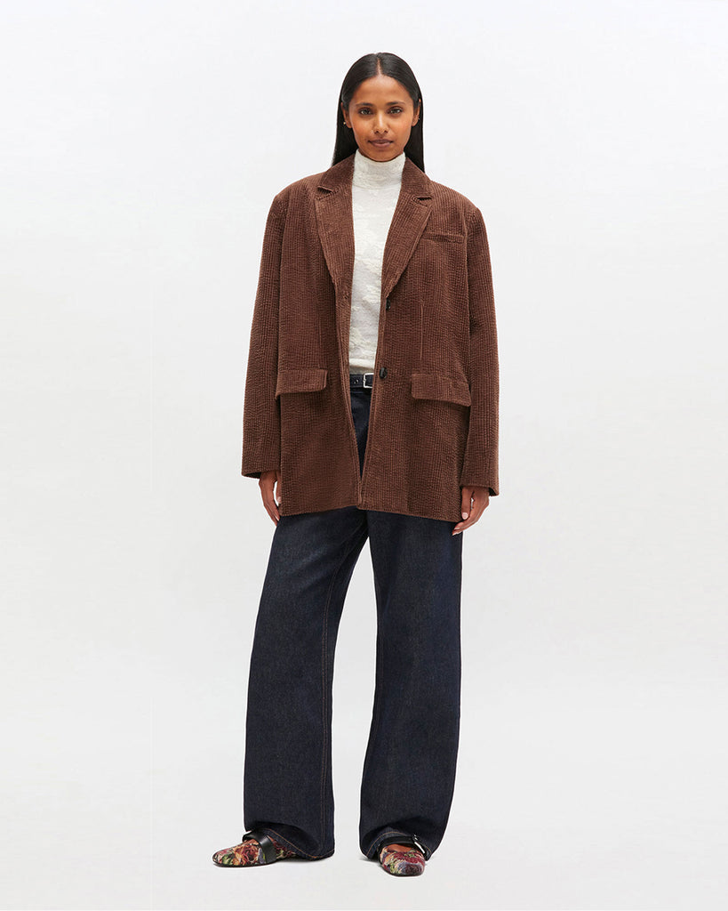 Luźna, prążkowana marynarka 0769 GANNI Chicory Coffee zapinana na dwa guziki z przodu.&nbsp; Posiada dwie, przednie kieszenie z klapkami i jedną kieszonkę nad lewą piersią. Marynarka ma prostu krój i luźny fason. Z tyłu posiada rozcięcie.&nbsp;Wykonana z bawełny organicznej.