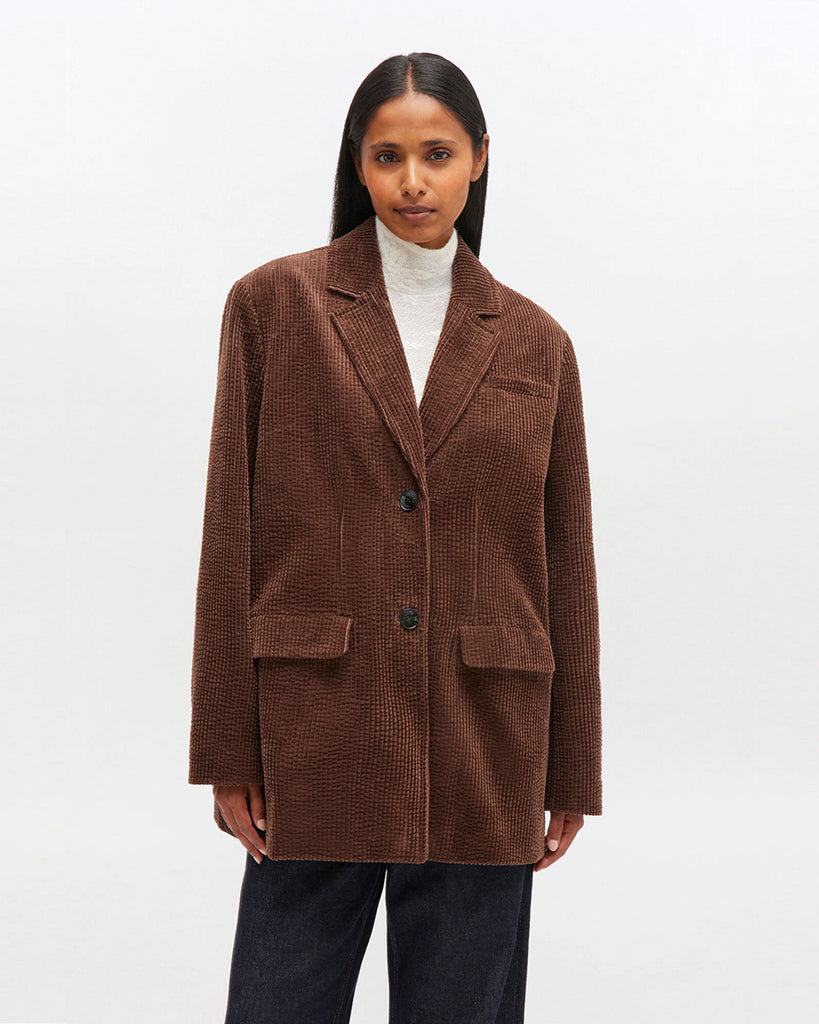 Luźna, prążkowana marynarka 0769 GANNI Chicory Coffee zapinana na dwa guziki z przodu.&nbsp; Posiada dwie, przednie kieszenie z klapkami i jedną kieszonkę nad lewą piersią. Marynarka ma prostu krój i luźny fason. Z tyłu posiada rozcięcie.&nbsp;Wykonana z bawełny organicznej.