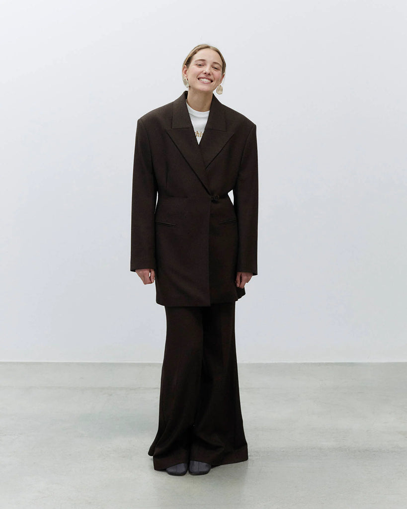 Bardzo długa, jednorzędowa marynarka Oversized Flannel Choco z wyraźnie zaznaczonymi ramionami i zwężeniem w talii. Ma asymetryczne zapięcie na guzik oraz kieszenie wpuszczane z przodu. Wykonana z mieszanki wełny i wiskozy.&nbsp;