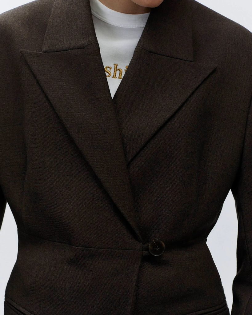 Bardzo długa, jednorzędowa marynarka Oversized Flannel Choco z wyraźnie zaznaczonymi ramionami i zwężeniem w talii. Ma asymetryczne zapięcie na guzik oraz kieszenie wpuszczane z przodu. Wykonana z mieszanki wełny i wiskozy.&nbsp;