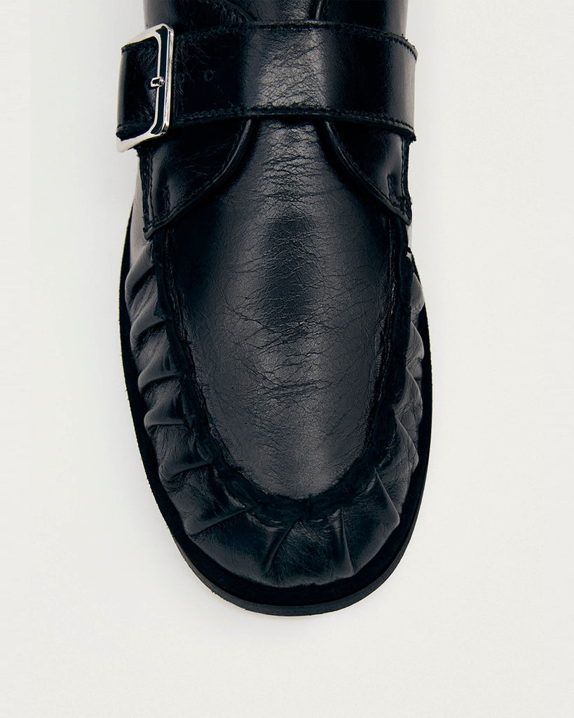 Czarne mokasyny Alohas Brandy Black Leather Loafers ze srebrną klamrą, która dodaje elegancji. Model charakteryzuje się unikatowym, marszczonym wykończeniem na nosku. Wykonane z wysokiej jakości skóry. Idealnie łączą ponadczasowy design z nowoczesnymi detalami.
