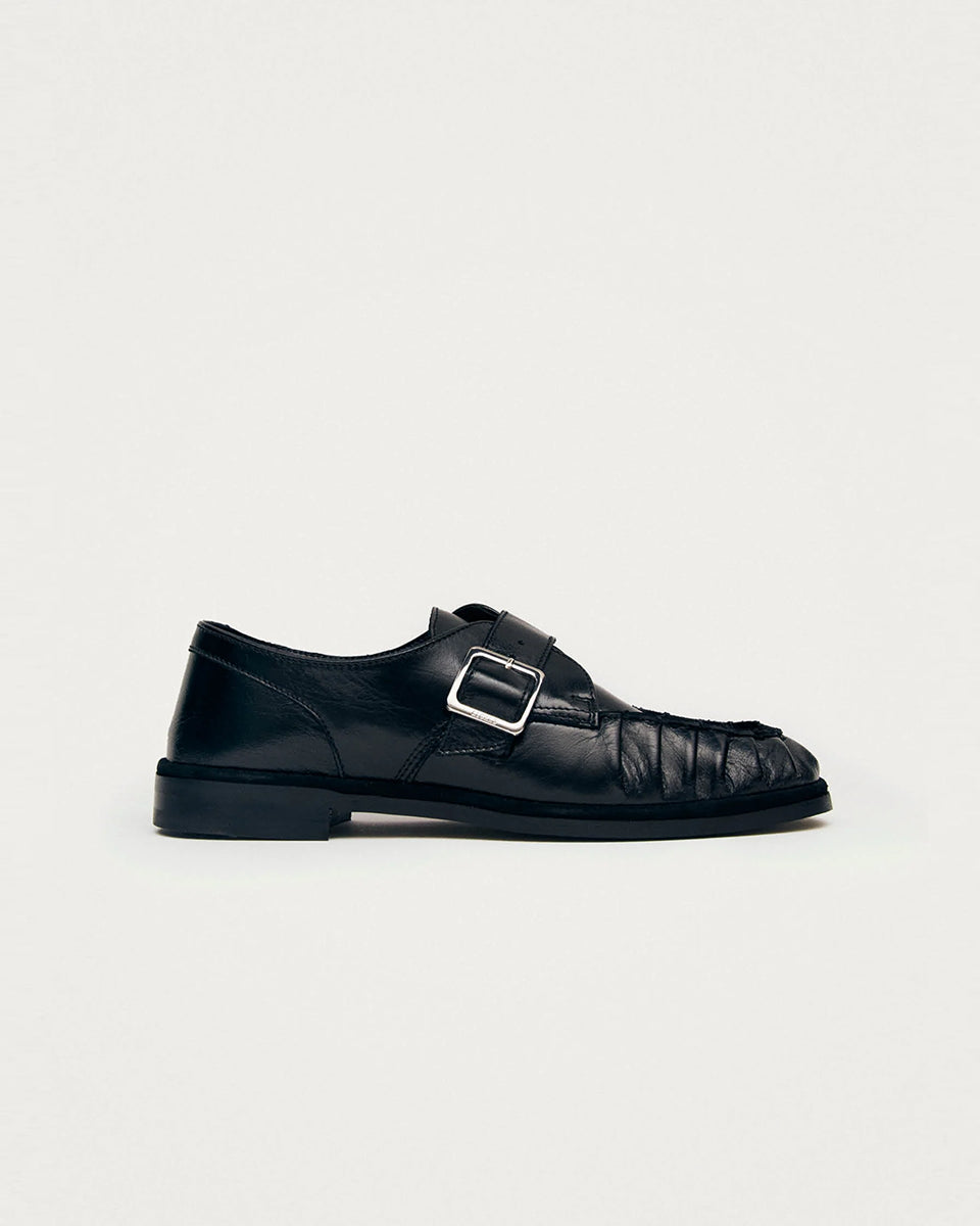 Czarne mokasyny Alohas Brandy Black Leather Loafers ze srebrną klamrą, która dodaje elegancji. Model charakteryzuje się unikatowym, marszczonym wykończeniem na nosku. Wykonane z wysokiej jakości skóry. Idealnie łączą ponadczasowy design z nowoczesnymi detalami.
