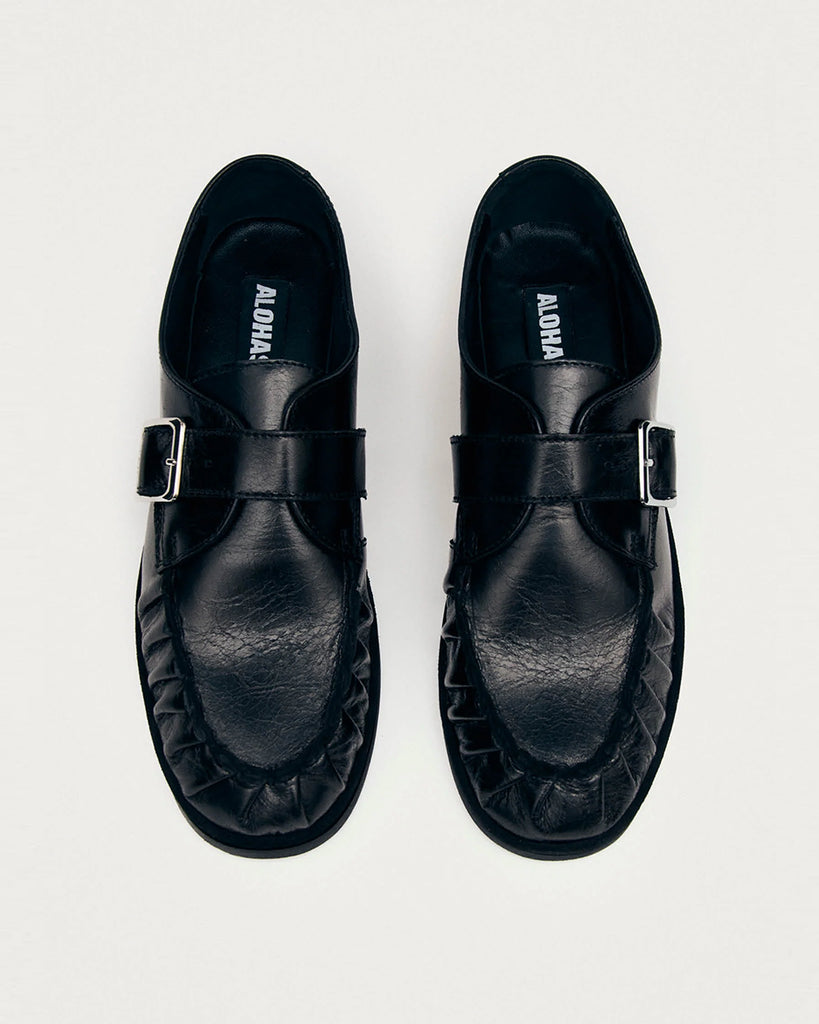 Czarne mokasyny Alohas Brandy Black Leather Loafers ze srebrną klamrą, która dodaje elegancji. Model charakteryzuje się unikatowym, marszczonym wykończeniem na nosku. Wykonane z wysokiej jakości skóry. Idealnie łączą ponadczasowy design z nowoczesnymi detalami.
