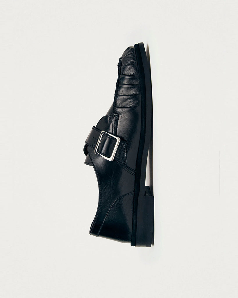 Czarne mokasyny Alohas Brandy Black Leather Loafers ze srebrną klamrą, która dodaje elegancji. Model charakteryzuje się unikatowym, marszczonym wykończeniem na nosku. Wykonane z wysokiej jakości skóry. Idealnie łączą ponadczasowy design z nowoczesnymi detalami.
