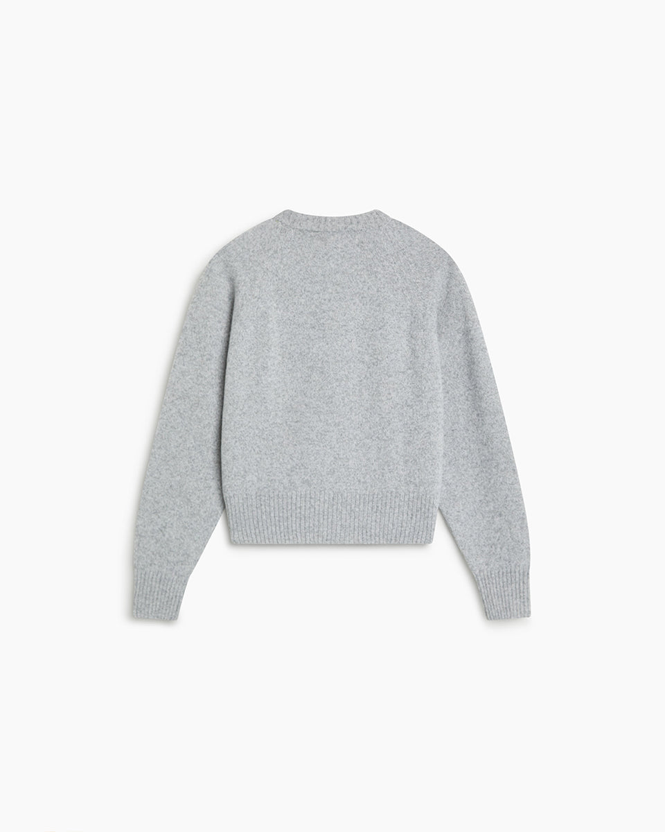 Jasny, szary sweter Breeze TNS Light Grey Melange o klasycznym, prostym kroju z okrągłym dekoltem wykończonym delikatnym ściągaczem. Posiada długie, nieco luźniejsze rękawy, które przy nadgarstkach przechodzą w szerokie ściągacze. Dół ma nieco krótszą długość, sięgającą do okolic pasa, co sprawia, że świetnie komponuje się z ciemnymi, szerokimi spodniami z wysokim stanem. Wykonany z mieszanki wełny merino i kaszmiru.

-Okrągły dekolt

-Wykończony ściągaczami&nbsp;

-Miękka tkanina z wełną merino i kaszmirem