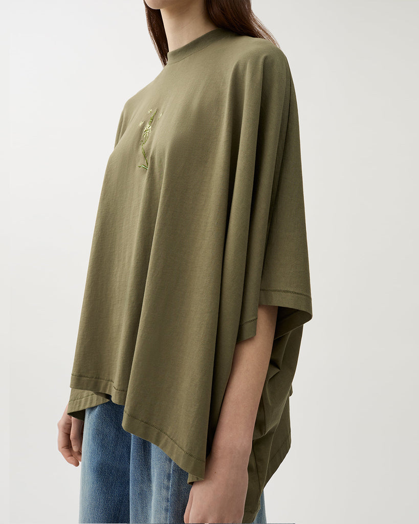 Oversizowy, lejący top Brick Kalamata Green z okrągłym dekoltem, opadającymi ramionami i luźnymi rękawami 3/4. Z przodu wyhaftowany jest kwiat. U dołu wykończony asymetrycznie. Wykonany z miękkiej bawełny organicznej.&nbsp;