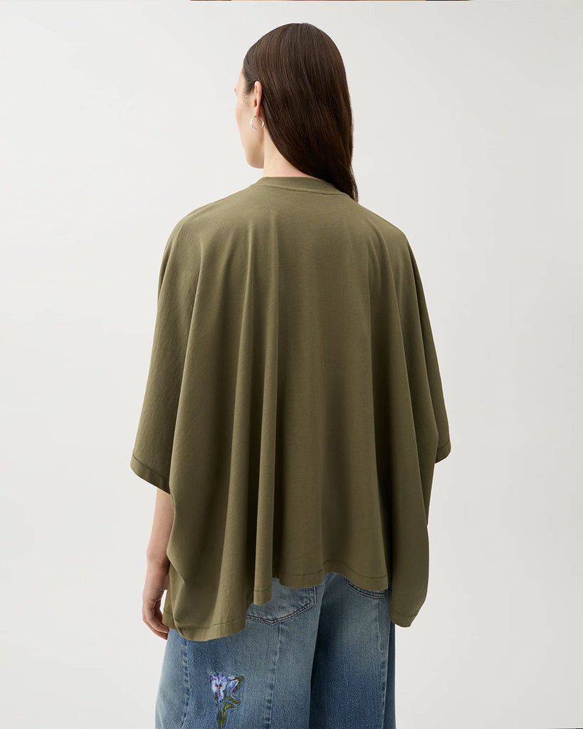 Oversizowy, lejący top Brick Kalamata Green z okrągłym dekoltem, opadającymi ramionami i luźnymi rękawami 3/4. Z przodu wyhaftowany jest kwiat. U dołu wykończony asymetrycznie. Wykonany z miękkiej bawełny organicznej.&nbsp;