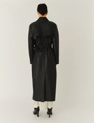 Długi, elegancki, dwurzędowy płaszcz Brooklyn Trench Black z klasycznymi detalami, wiązany w talii za pomocą wyciąganego, szerokiego paska. Posiada kołnierzyk, pagony na ramionach i luźne rękawy. Z tyłu u dołu ma rozcięcie. Płaszcz posiada dwie, boczne kieszenie. Jest zapinany na guziki. Wykończony w matowym, czarnym kolorze.
