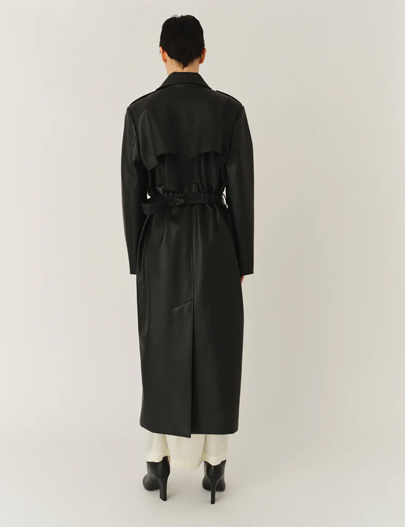 Długi, elegancki, dwurzędowy płaszcz Brooklyn Trench Black z klasycznymi detalami, wiązany w talii za pomocą wyciąganego, szerokiego paska. Posiada kołnierzyk, pagony na ramionach i luźne rękawy. Z tyłu u dołu ma rozcięcie. Płaszcz posiada dwie, boczne kieszenie. Jest zapinany na guziki. Wykończony w matowym, czarnym kolorze.