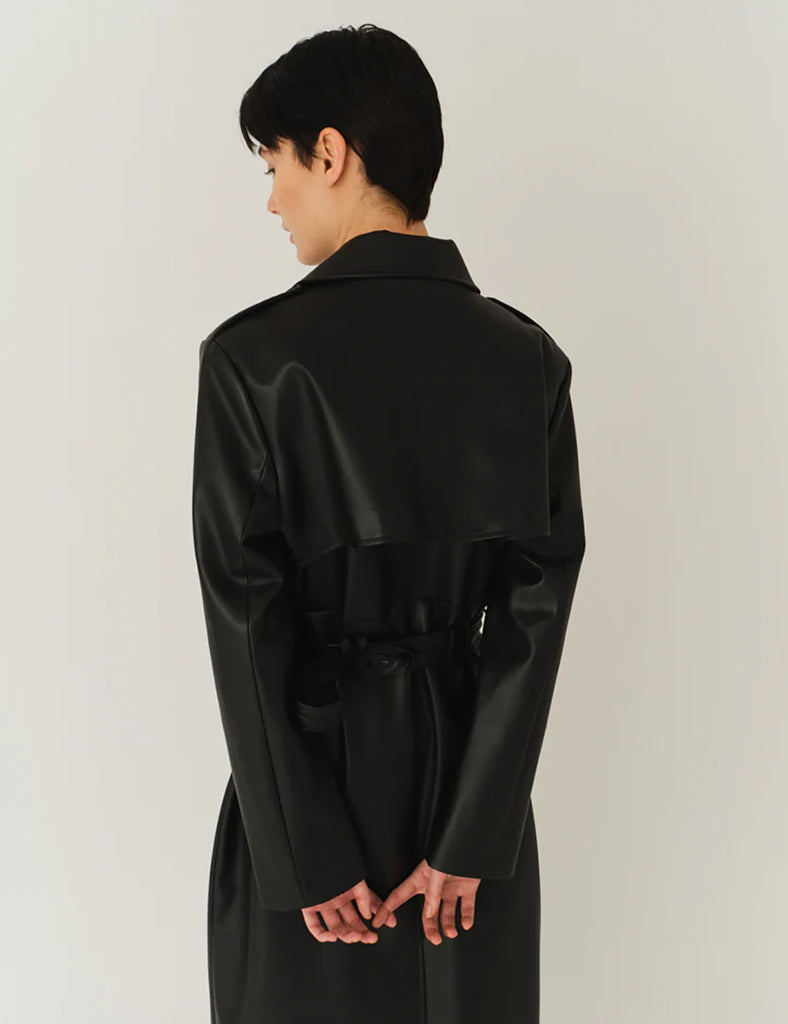 Długi, elegancki, dwurzędowy płaszcz Brooklyn Trench Black z klasycznymi detalami, wiązany w talii za pomocą wyciąganego, szerokiego paska. Posiada kołnierzyk, pagony na ramionach i luźne rękawy. Z tyłu u dołu ma rozcięcie. Płaszcz posiada dwie, boczne kieszenie. Jest zapinany na guziki. Wykończony w matowym, czarnym kolorze.