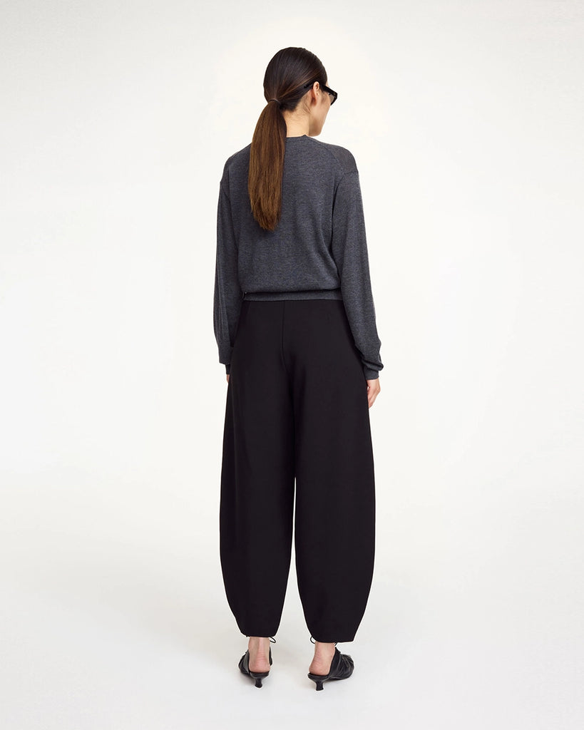 Klasyczne, garniturowe spodnie Carlien By Malene Birger z wysokim stanem i zaokrągloną, zwężaną u dołu nogawką w typie barrel cut. Spodnie posiadają dwie, boczne kieszenie i szlufki na pasek