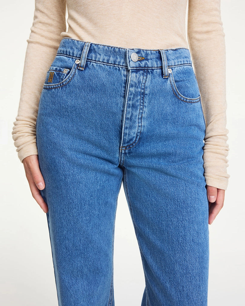 Klasyczne, niebieskie jeansy Chicago By Malene Birger z wysokim stanem i prostą nogawką. Przylegająca w biodrach. Posiadają pięć kieszenie. Na najmniejszej kieszonce z prawej strony posiadają niewielkie, haftowane logo marki