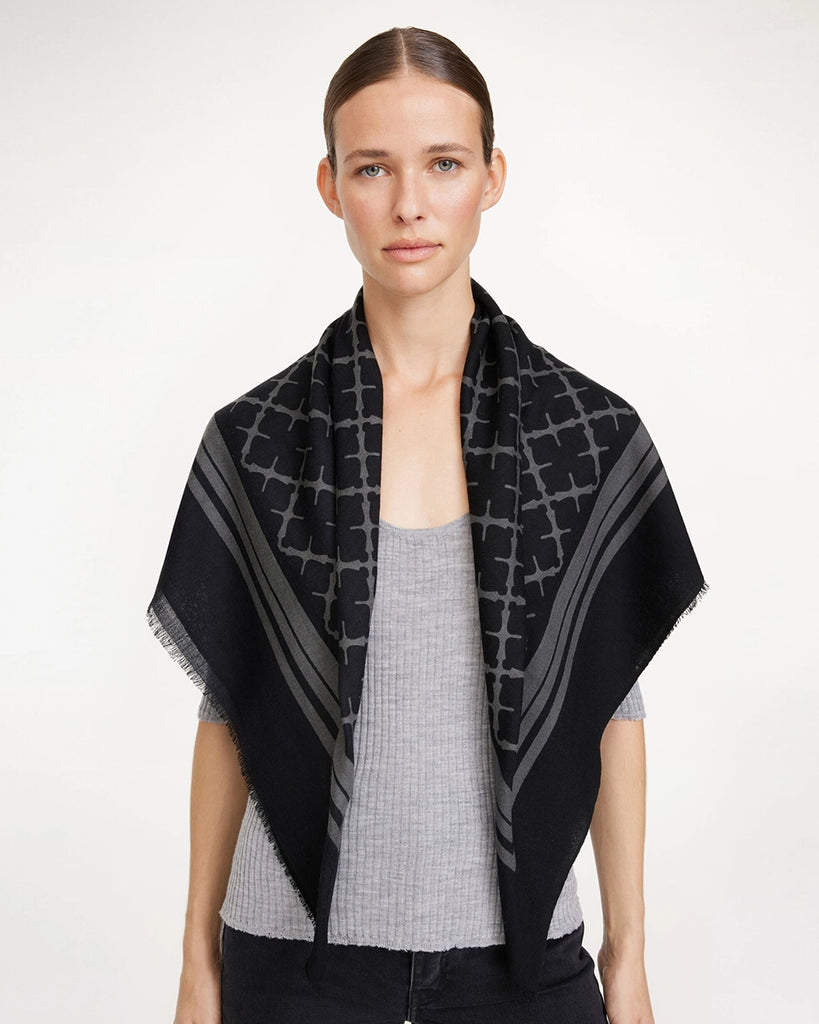 Duża, wełniana chusta Cornelis By Malene Birger o kwadratowym kształcie z kontrastowym printem. Wykończona delikatnymi frędzlami. 