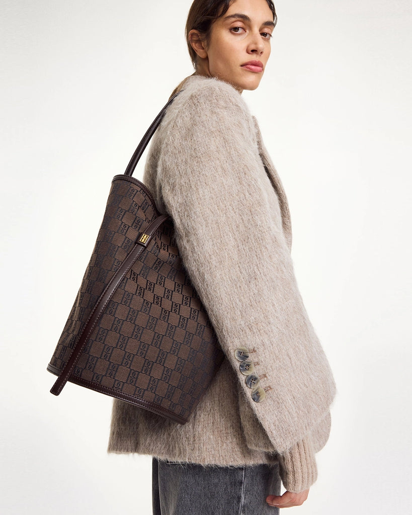 Średniej wielkości torebka kubełek Maryllon By Malene Birger z tkaniny w charakterystyczny dla marki wzór z emblematem. Torebka ma cienki pasek do wygodnego zawieszenia na ramieniu.