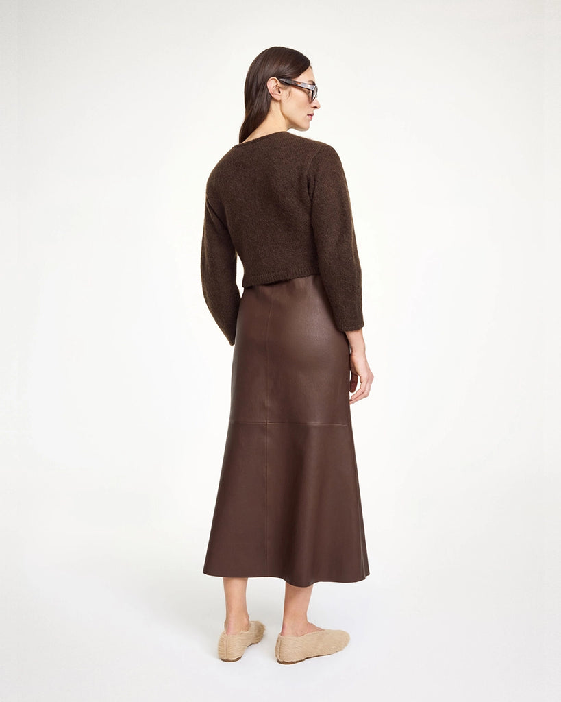 Brązowy, krótki, pudełkowy kardigan Zharea By Malene Birger z okrągłym dekoltem, opadającymi ramionami i szerokimi rękawami delikatnie zwężanymi przy nadgarstkach. Zapinany na obszyte dzianiną guziki.