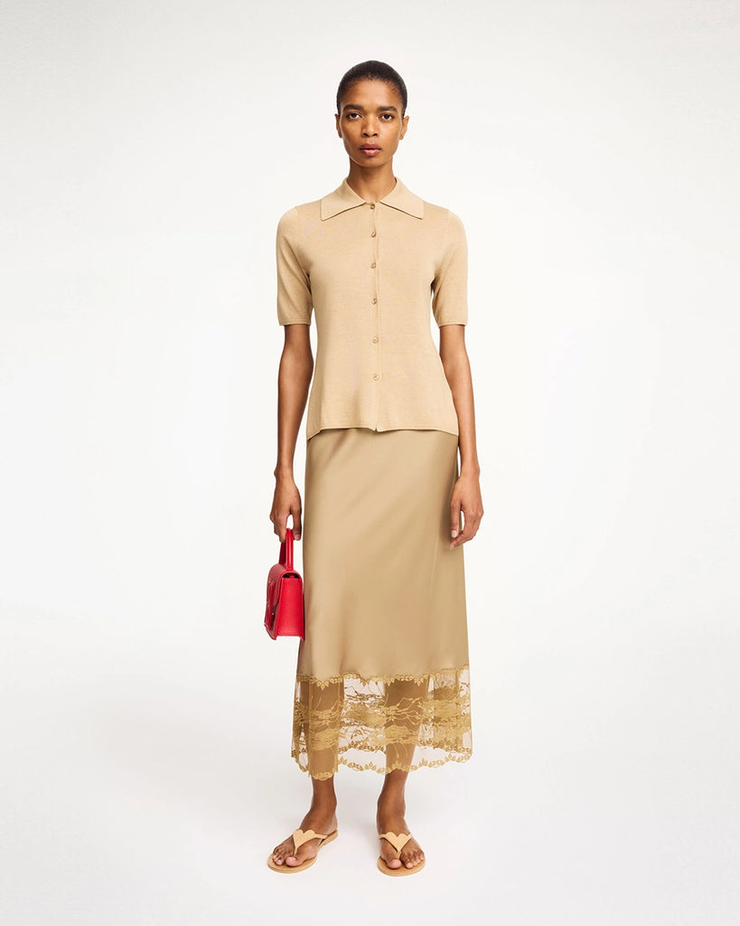 Cienka, satynowa spódnica midi Blake By Malene Birger z wysokim stanem. U dołu wykończona delikatną, ażurową koronką. Elastyczna w talii. Elegancka i codzienna zarazem. 