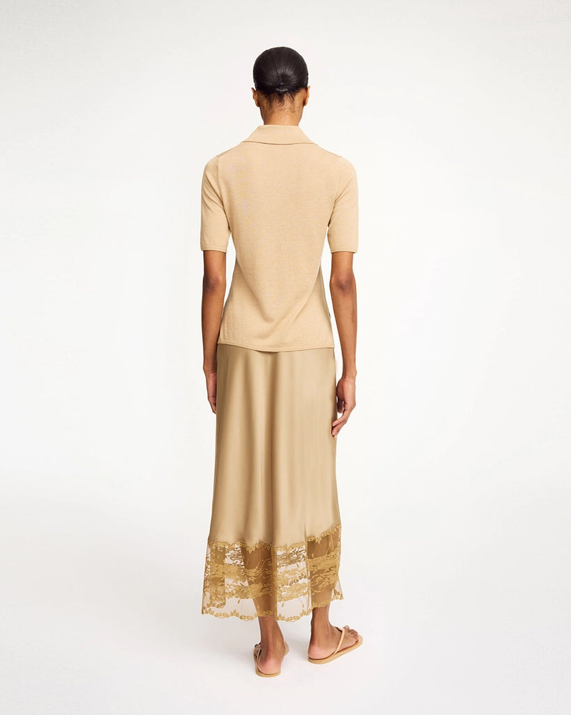 Cienka, satynowa spódnica midi Blake By Malene Birger z wysokim stanem. U dołu wykończona delikatną, ażurową koronką. Elastyczna w talii. Elegancka i codzienna zarazem. 