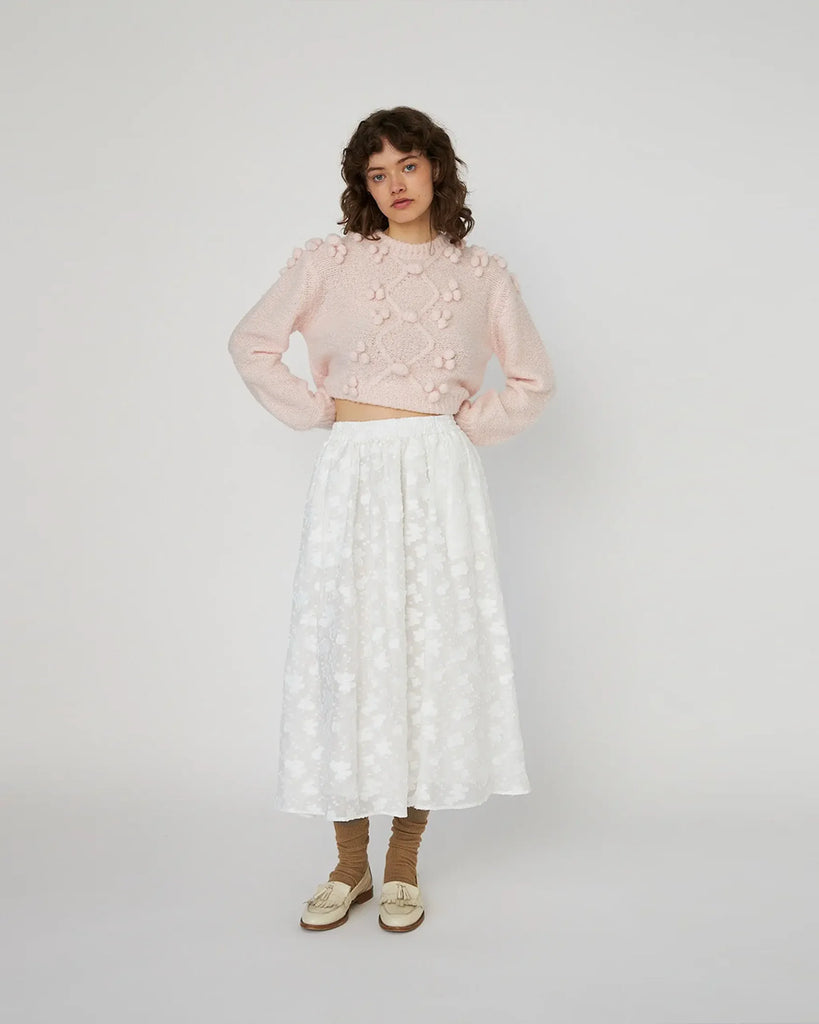 Wełniany, krótki sweter Cable with Bobbles Pink marki STELLA NOVA z okrągłym dekoltem i długimi rękawami. Posiada zdobienia w formie trójwymiarowych pomponów. Idealnie pasuje do spodni lub spódnicy z wysokim stanem. Wykonany z dzianiny z wełny.