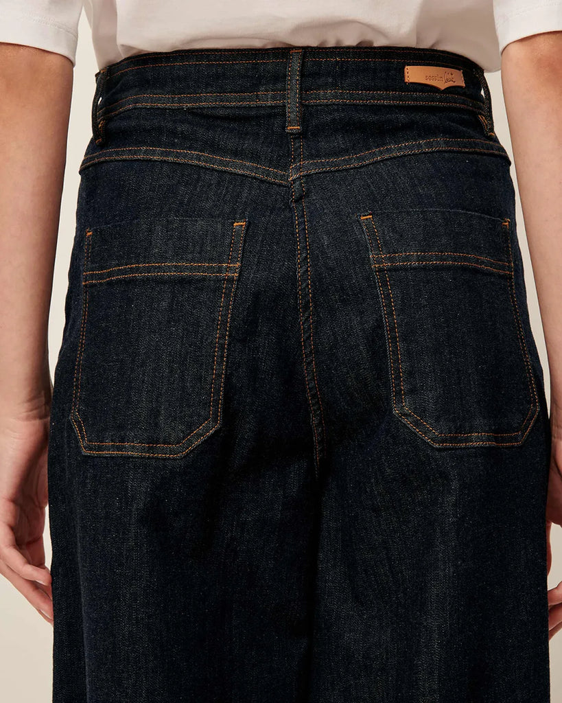 Ciemne Jeansy Captain Denim Rince z wysokim stanem i szerokimi nogawkami wykonane z denimu stonewash. Zapinane na guzik i kryty zamek błyskawiczny. Mają kieszenie z przodu oraz z tyłu i wytłoczoną, skórzaną naszywkę z logo marki.