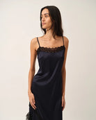Elegancka, lejąca sukienka maxi na cienkich, regulowanych ramiączkach Cata Lace The Garment wykończona zmysłową koronką. Posiada prosty dekolt i głębokie wycięcie na plecach. Z przodu dekorowana asymetryczną koronką. Sukienka ma boczne rozcięcie oraz długość do kostek. Z tyłu delikatnie drapowana. Wykonana z jedwabnej, śliskiej tkaniny.