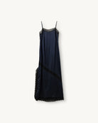 Elegancka, lejąca sukienka maxi na cienkich, regulowanych ramiączkach Cata Lace The Garment wykończona zmysłową koronką. Posiada prosty dekolt i głębokie wycięcie na plecach. Z przodu dekorowana asymetryczną koronką. Sukienka ma boczne rozcięcie oraz długość do kostek. Z tyłu delikatnie drapowana. Wykonana z jedwabnej, śliskiej tkaniny.