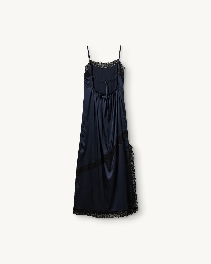 Elegancka, lejąca sukienka maxi na cienkich, regulowanych ramiączkach Cata Lace The Garment wykończona zmysłową koronką. Posiada prosty dekolt i głębokie wycięcie na plecach. Z przodu dekorowana asymetryczną koronką. Sukienka ma boczne rozcięcie oraz długość do kostek. Z tyłu delikatnie drapowana. Wykonana z jedwabnej, śliskiej tkaniny.