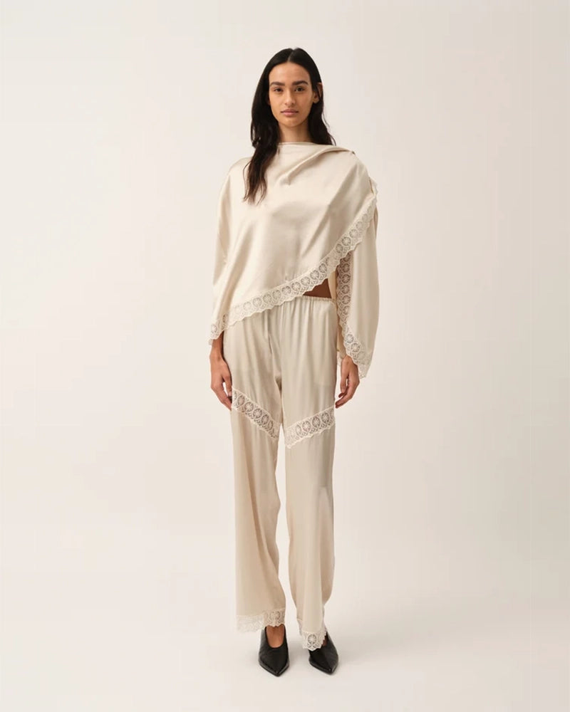 Elegancka, jedwabna peleryna Cata The Garment o asymetrycznym fasonie. Zebrana na lewym ramieniu. Wykończona zmysłową koronką. Wykonana z lejącej, jedwabnej tkaniny.  