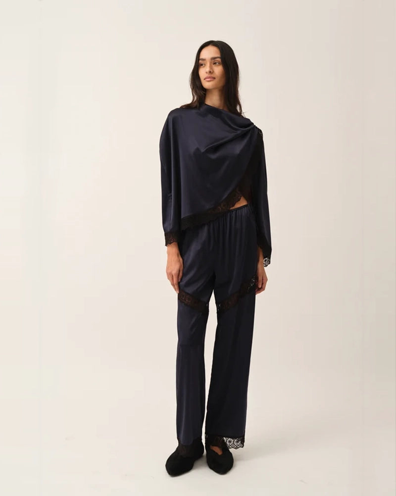 Lejące, jedwabne spodnie Cata Lace The Garment ze średnim stanem i prostą, luźną nogawką. Wiązane na bokach bioder. Wykończone zmysłową koronką. Idealne na co dzień i do wieczorowej, eleganckiej stylizacji. 