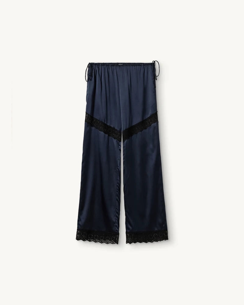 Lejące, jedwabne spodnie Cata Lace The Garment ze średnim stanem i prostą, luźną nogawką. Wiązane na bokach bioder. Wykończone zmysłową koronką. Idealne na co dzień i do wieczorowej, eleganckiej stylizacji. 